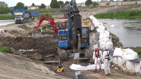 Chantier de dépollution URANO - agents en combinaison sur une berge en traitement