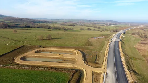 Construction de l'autoroute A304 : chaussée neuve et bassin de rétention en cours de façonnage
