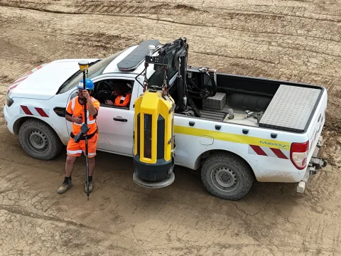 Véhicule du laboratoire URANO sur un chantier, Maxidyn suspendu à la grue et technicien avec sa canne GPS