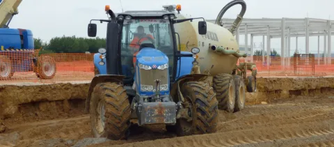 Tracteur équipé d'une citerne sur une plateforme de chantier