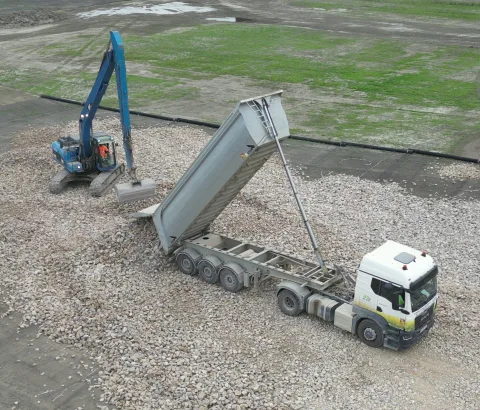 Semi-benne en cours de déchargement sur une plateforme